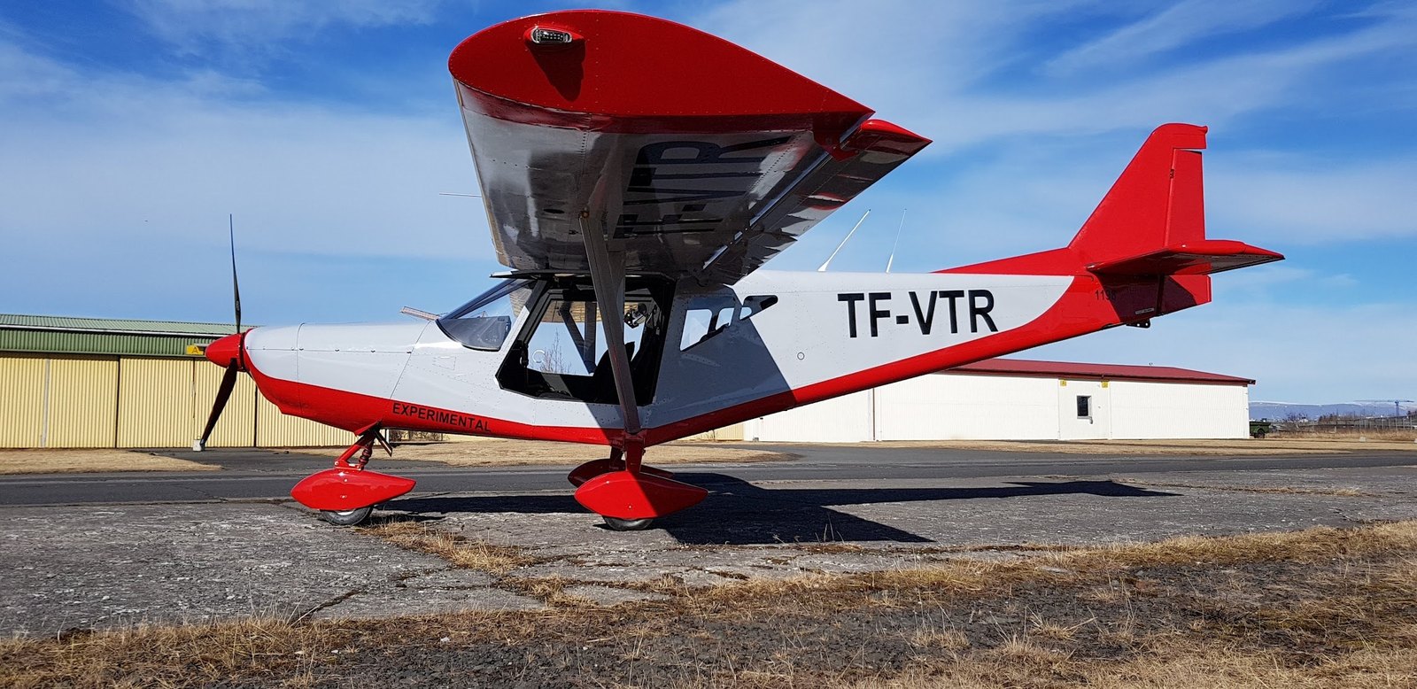 A red and white experimental aircraft, TF-VTR, parked at Reykjavík airport